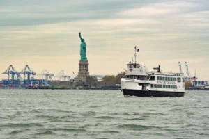 HOME 9 A ferry cruises past the iconic Statue of Liberty in New York Harbor, USA.
