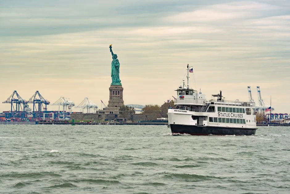 Blog Renny NYC 3 A ferry cruises past the iconic Statue of Liberty in New York Harbor, USA.