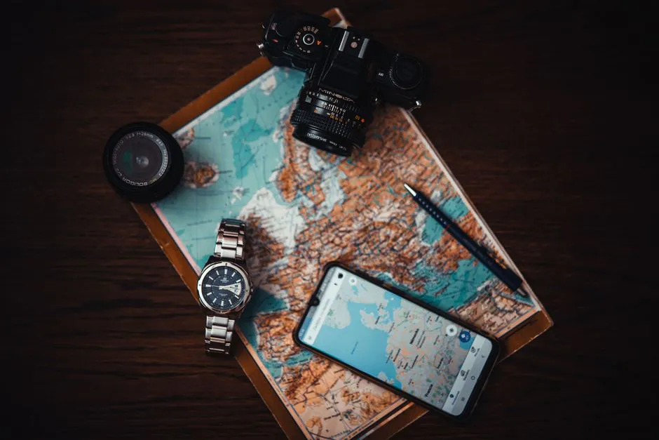 Roteiros em Nova York: o que o ChatGPT não mostra 1 Top view of travel essentials including a map, camera, phone, watch, and lens on a wooden surface.